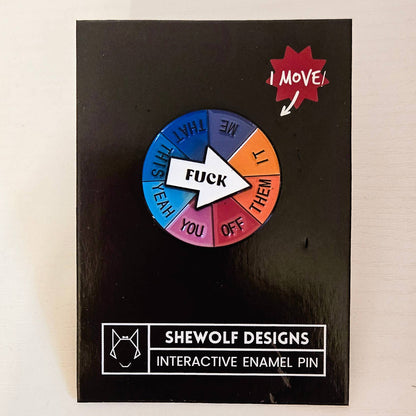 Interactive enamel pin with colorful wheel and text on a black card, branded &