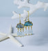 Close up view of labradorite and aquamarine chandelier earrings hanging from a white coral branch.