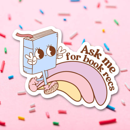 Sticker with a cartoon book character on a pink background with sprinkles.