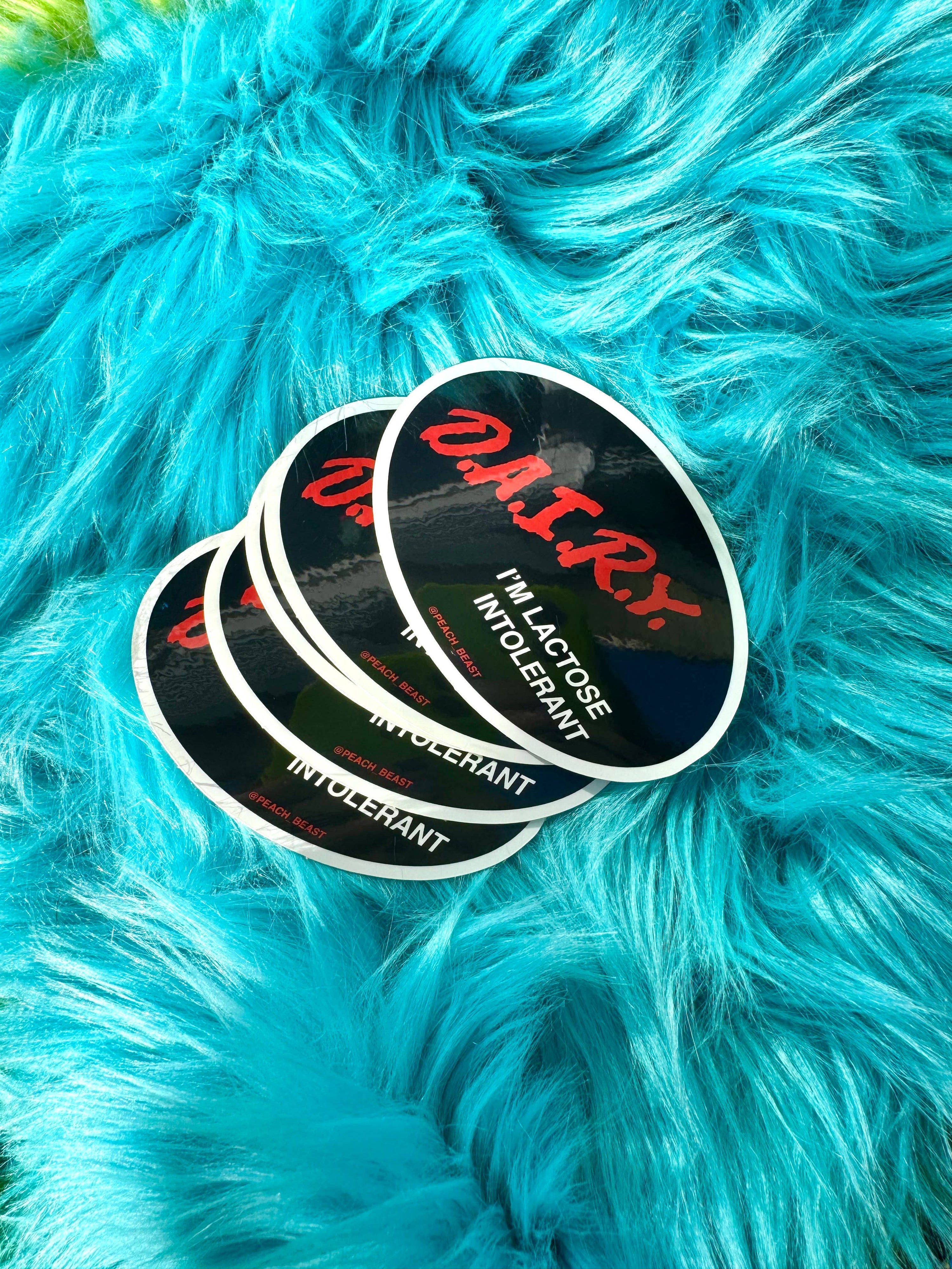 Three stickers with text on a blue furry surface
