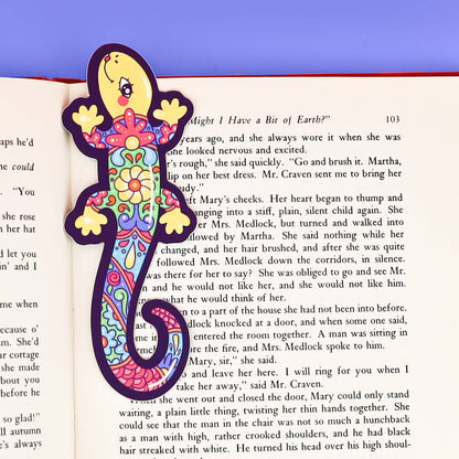 Colorful lizard-shaped bookmark on an open book