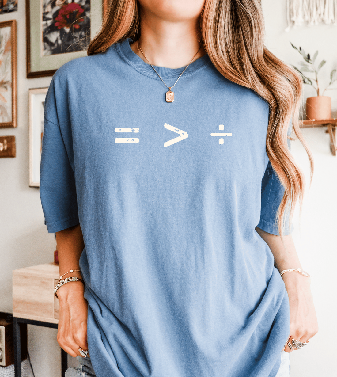 Person wearing a blue t-shirt with equation symbol of equality is greater than division