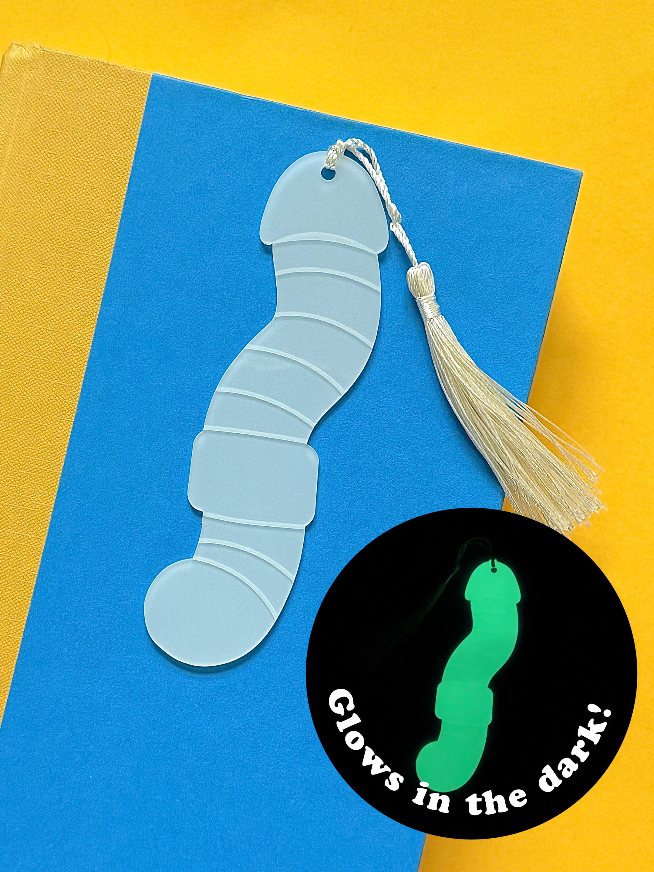 Glowing blue worm-shaped bookmark with tassel on a yellow background