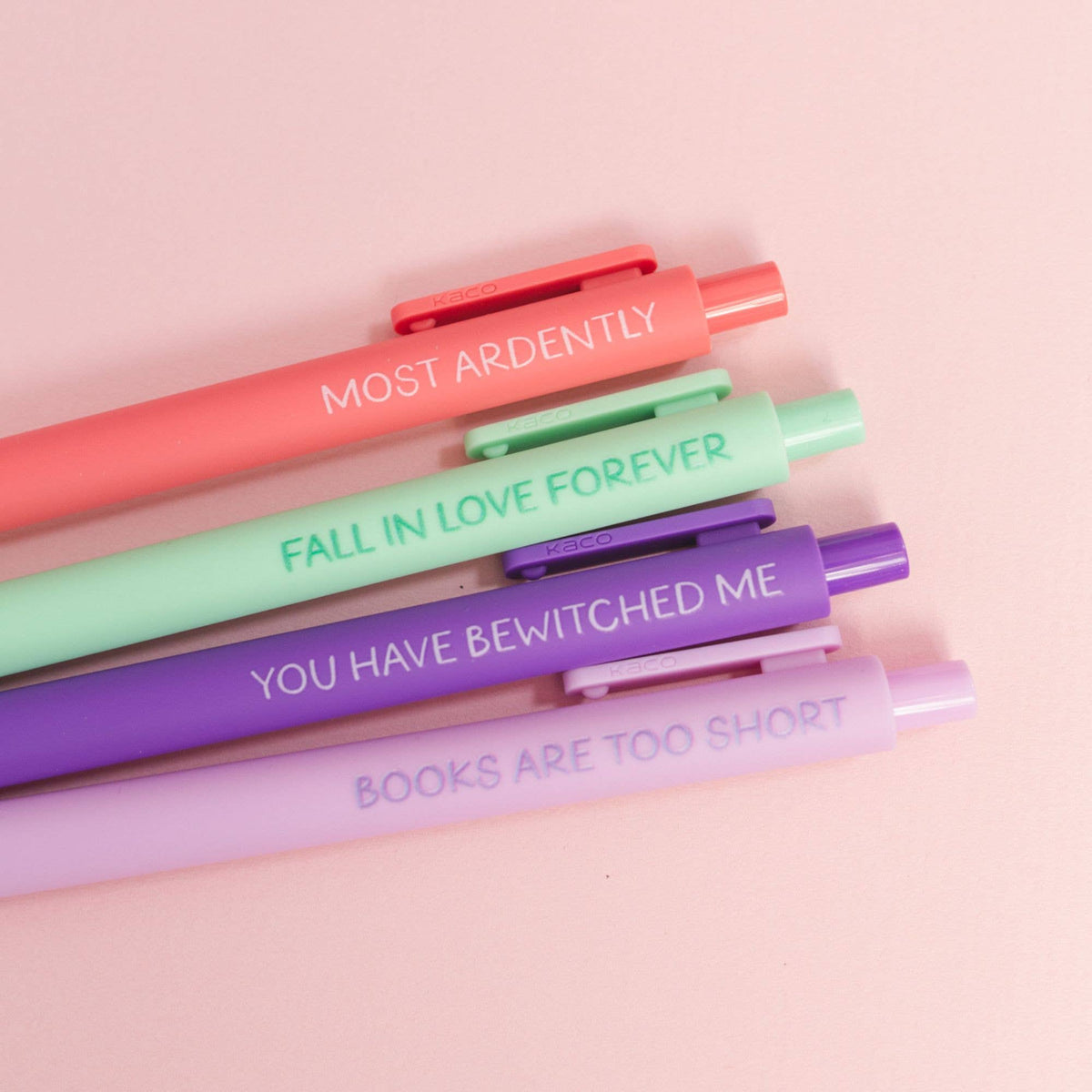 Set of colorful pens with motivational text on a pink background