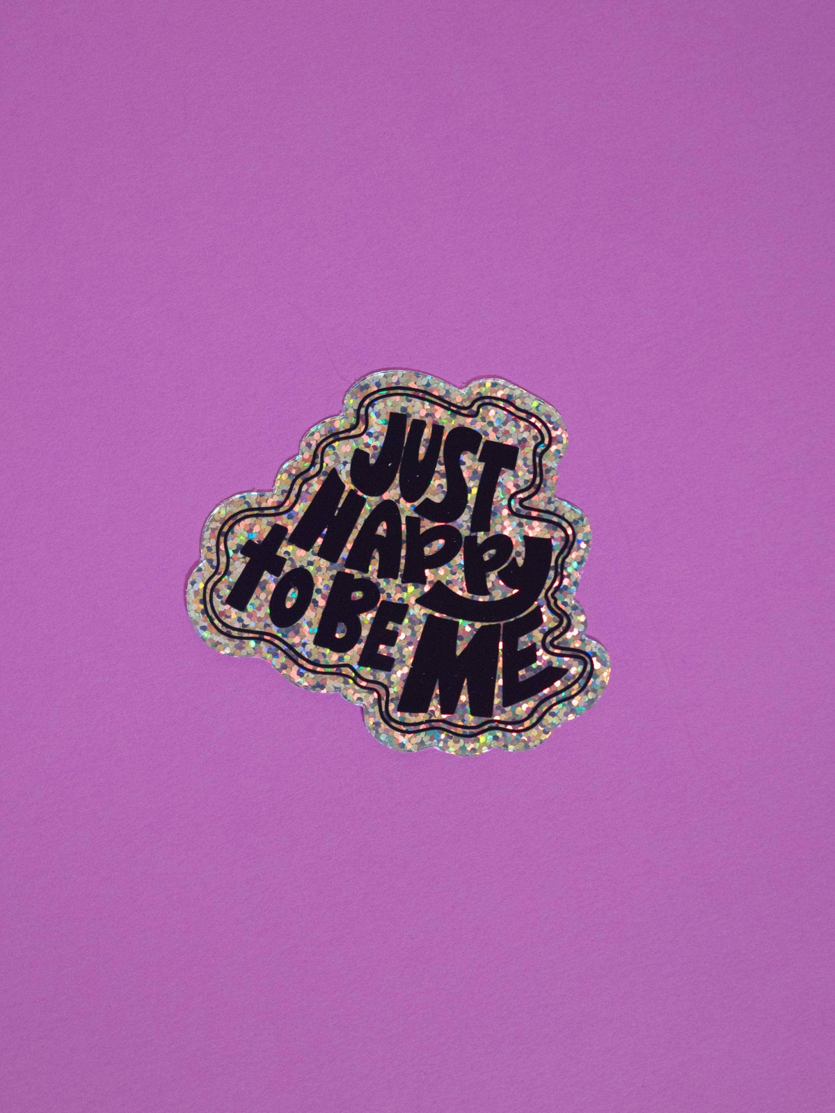 A die-cut sticker with the text &