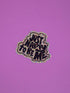 A die-cut sticker with the text &