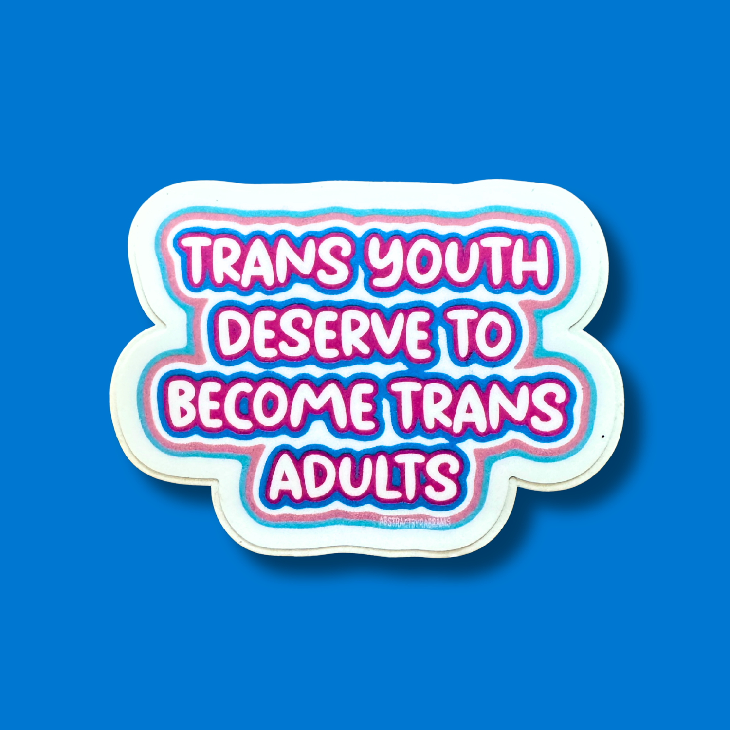 A die-cut sticker with the text &
