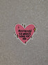 Pink heart-shaped sticker with text on a glittery gray background
