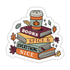 A die-cut sticker featuring a stack of four books with autumn-themed illustrations, including a coffee cup, leaves, and stars. The books are labeled &