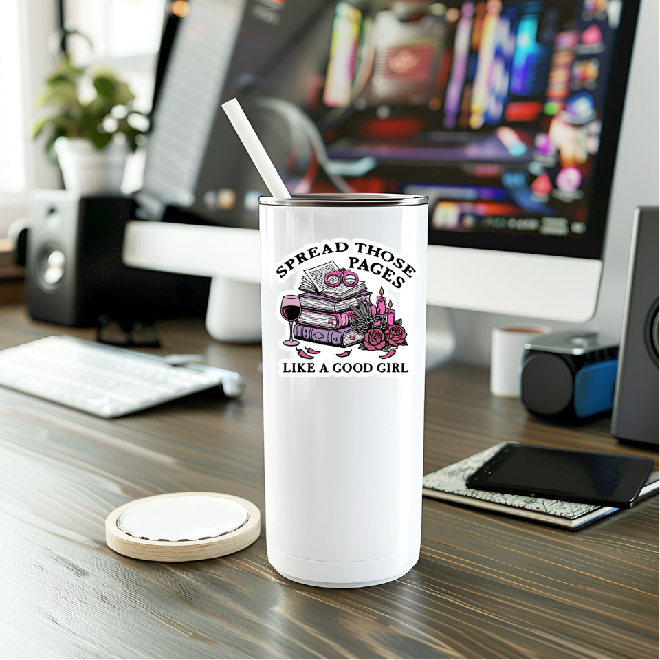 White tumbler with a design and text on a desk with a computer in the background