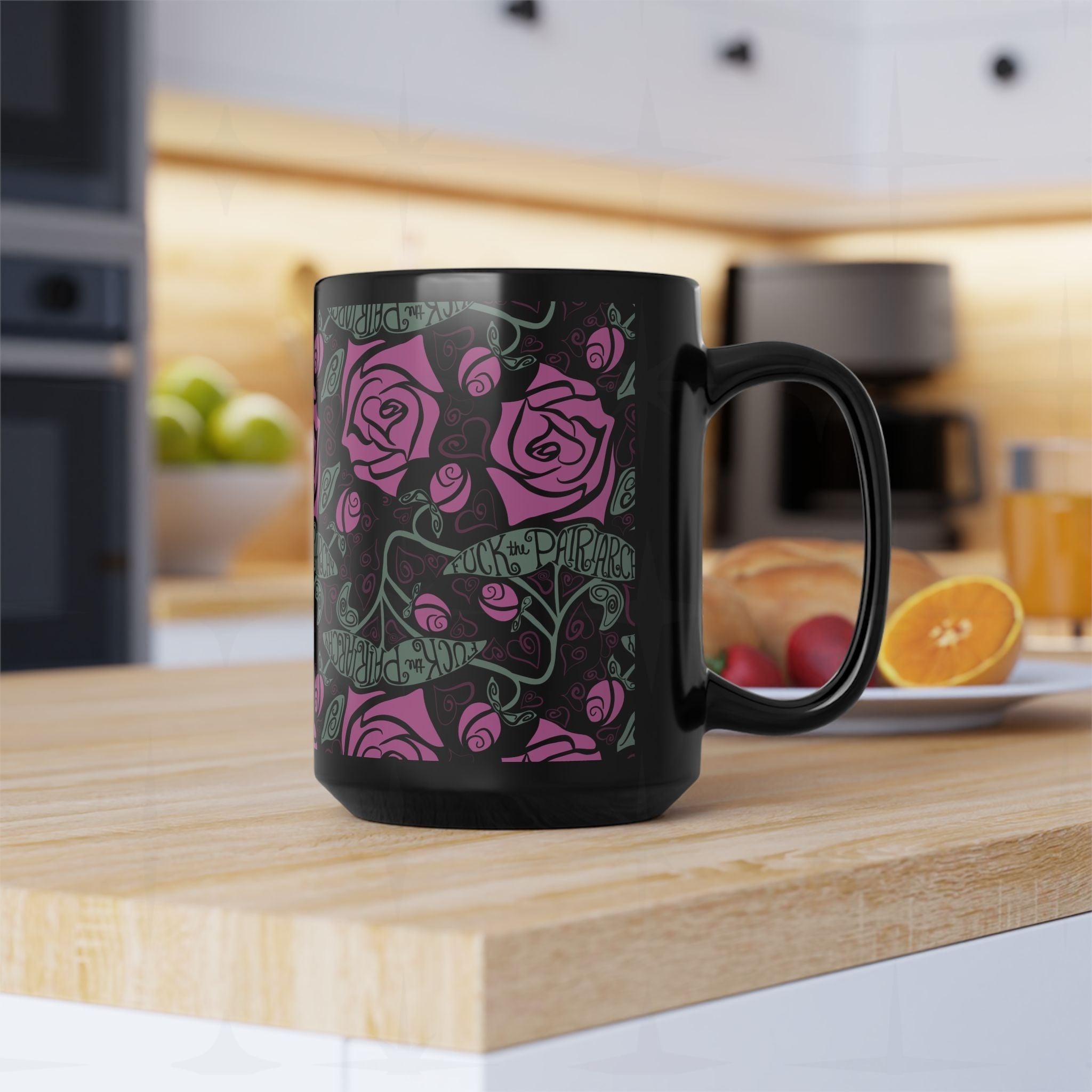Glossy black ceramic feminist mug with fuchsia rose and Fuck the Patriarchy hand-lettered pattern displayed on butcher block kitchen counter