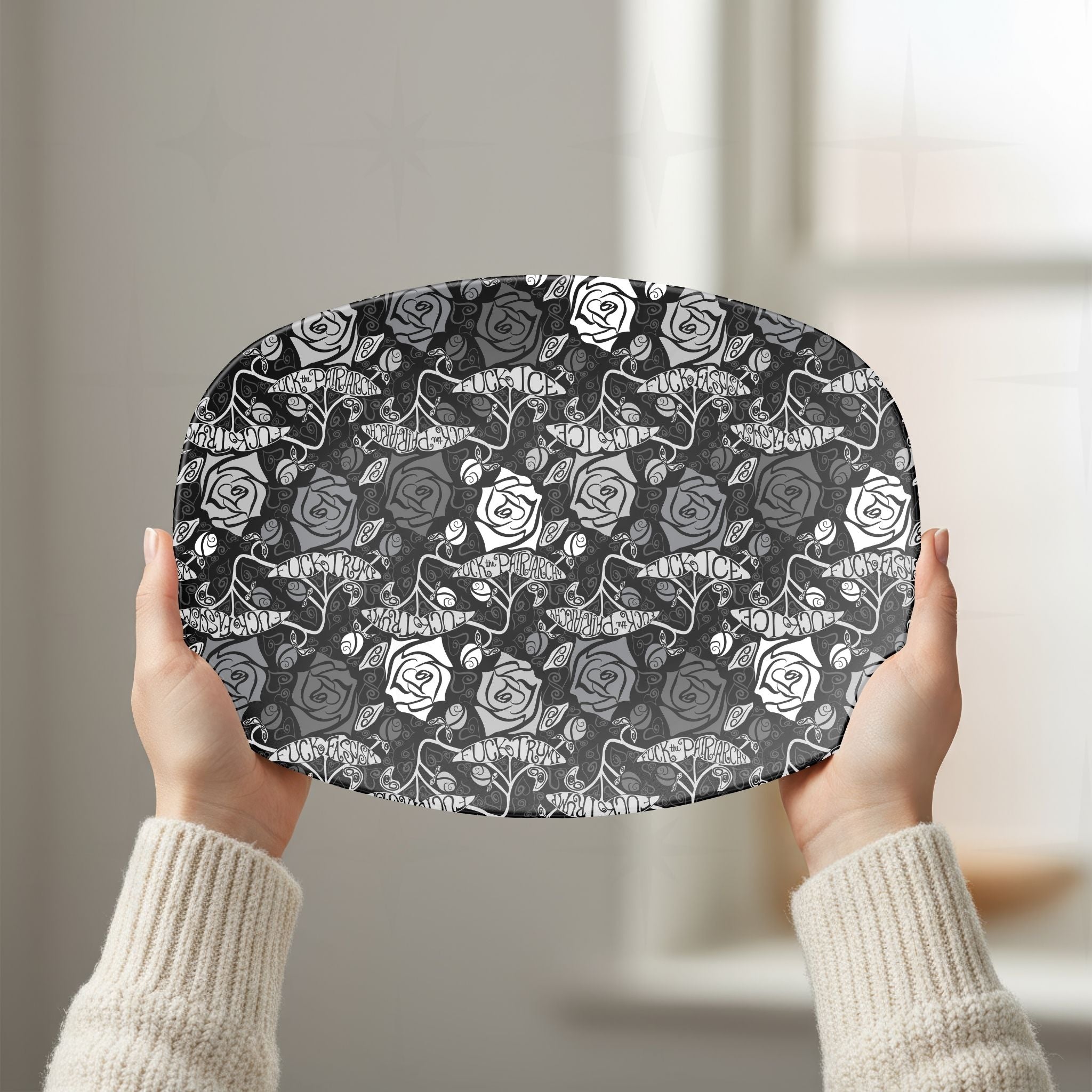 Person in cream sweater holding feminist hidden profanity serving platter showing dark gothic rose repeat pattern in white kitchen
