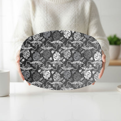 Person in cream sweater holding feminist hidden profanity serving platter showing dark gothic rose repeat pattern in white kitchen