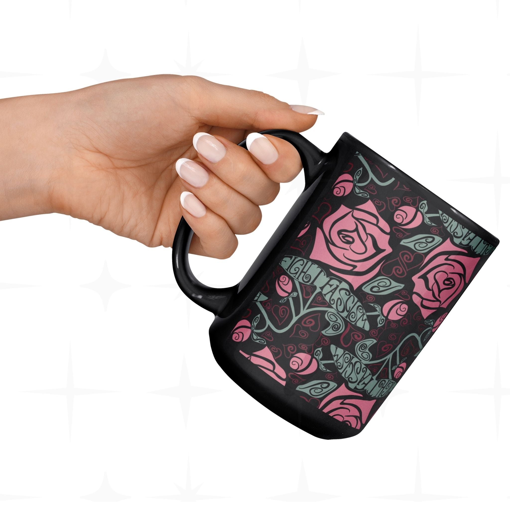 Hand holding the Fight Fascism black ceramic mug showing full Art Nouveau rose wrap print and hand-lettered protest message in vine stems