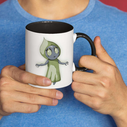 Person in a blue shirt holding the cute Flatwoods Monster cryptid coffee mug