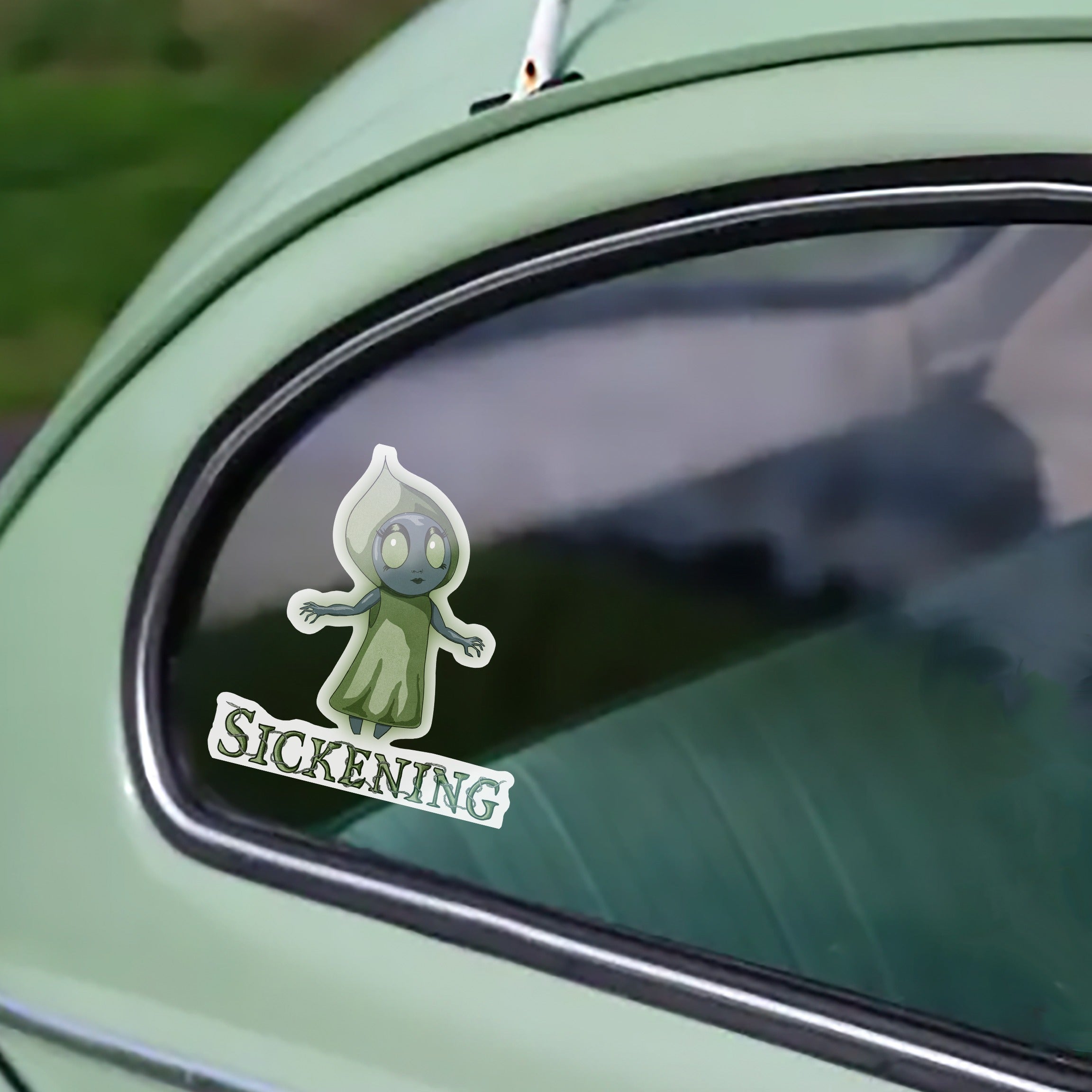 Flatwoods Monster cryptid sticker on the rear window of a mint-green vintage car