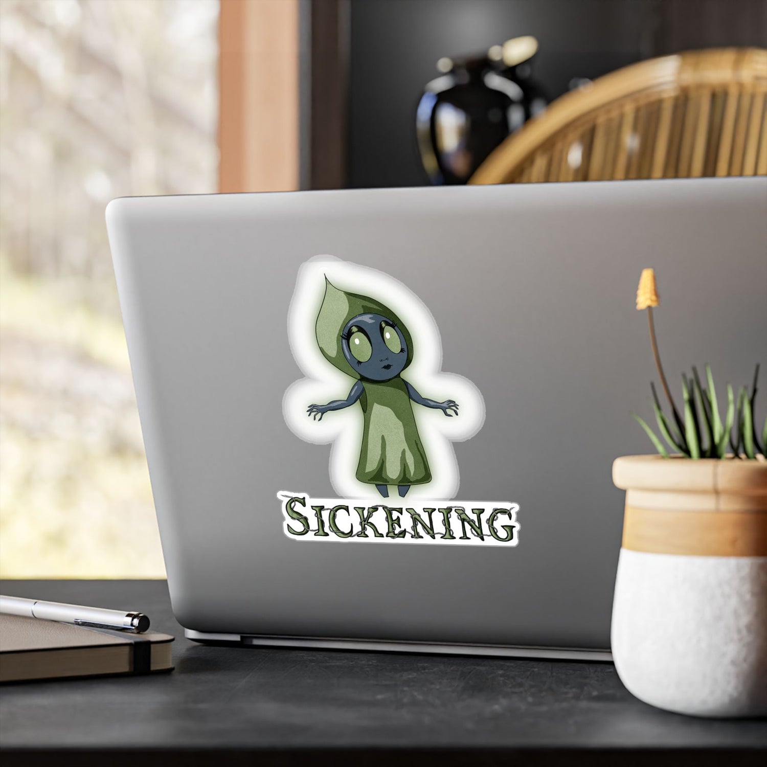 Large Flatwoods Monster cryptid sticker on the back of a silver laptop