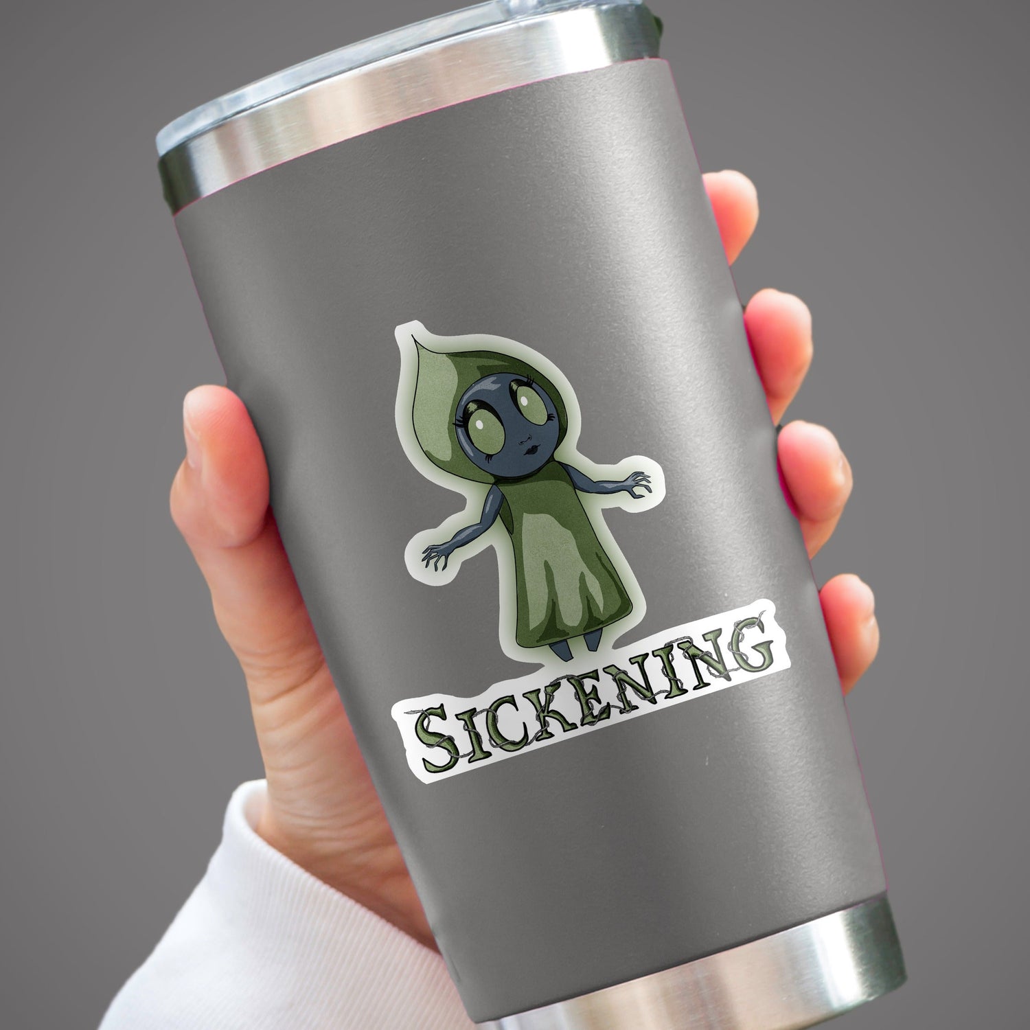 Flatwoods Monster cryptid sticker on a gray tumbler held in one hand