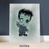 Frankenstein art print in the 8x10 inch size, leaning against a navy blue wall on a light wood floor.