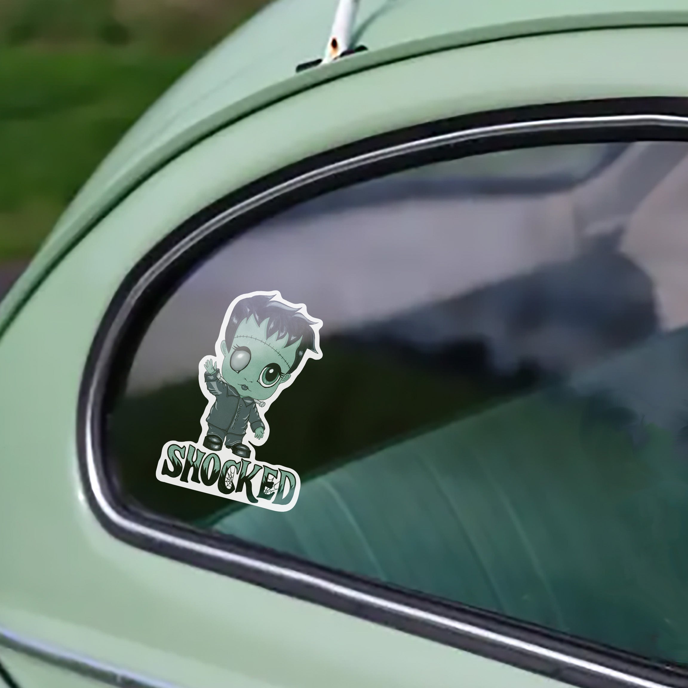 Creepy cute Frankenstein sticker on the window of a mint-green vintage car