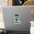 Small chibi Frankenstein sticker with mint-green skin and SHOCKED lettering on the back of a silver laptop