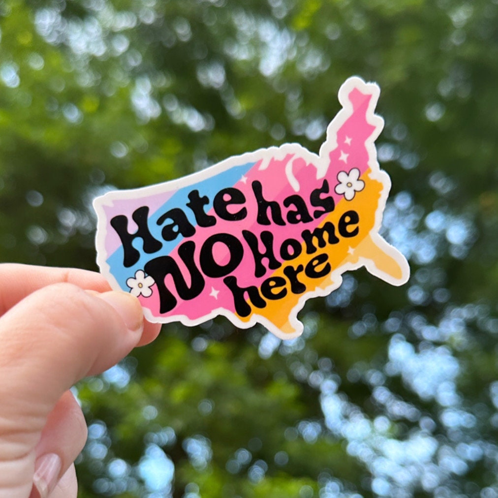 Hate Has No Home Here text in a colorful drawing of the shape of the continental United States, being held by a hand.