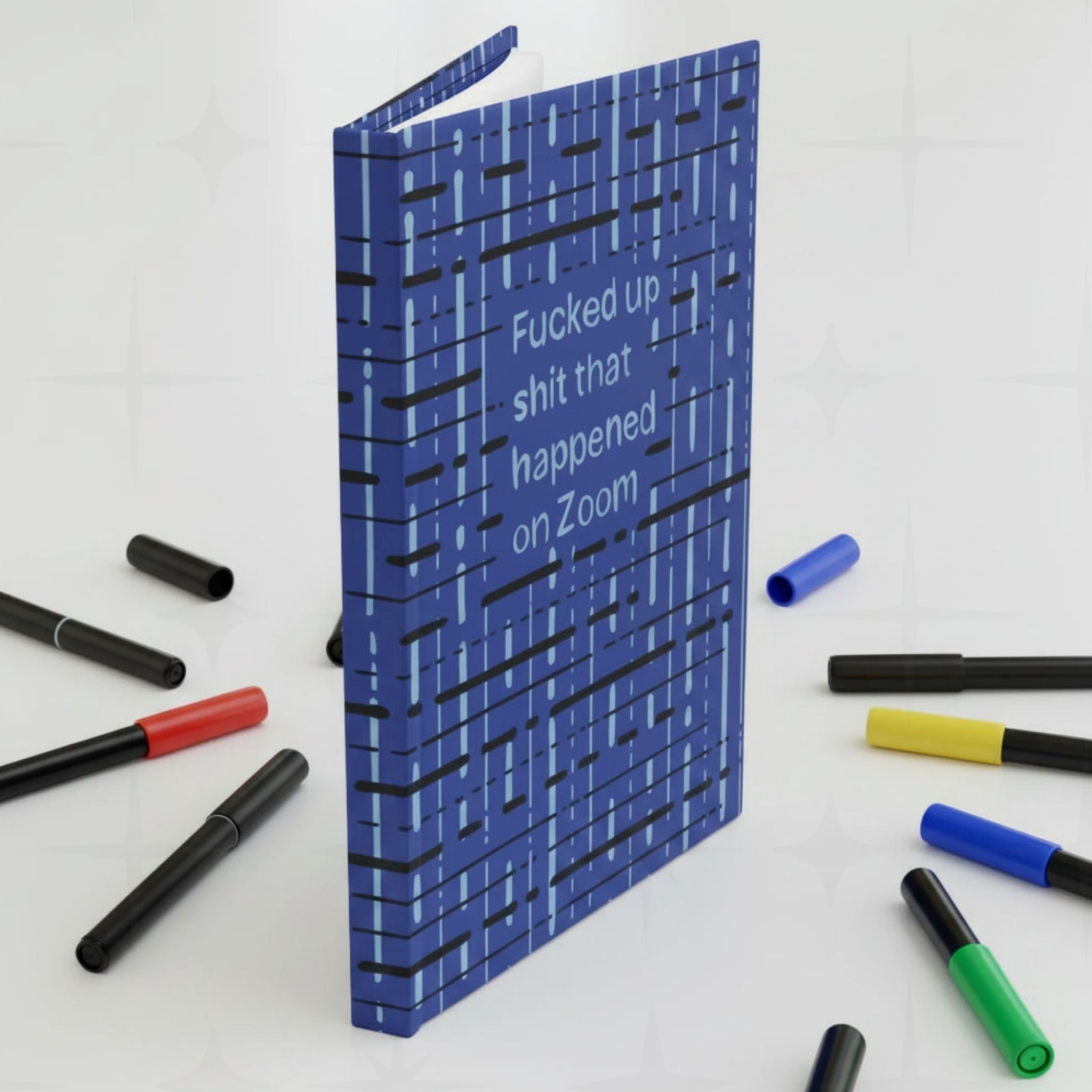 Funny Zoom profanity hardcover journal standing upright surrounded by colorful markers on white surface
