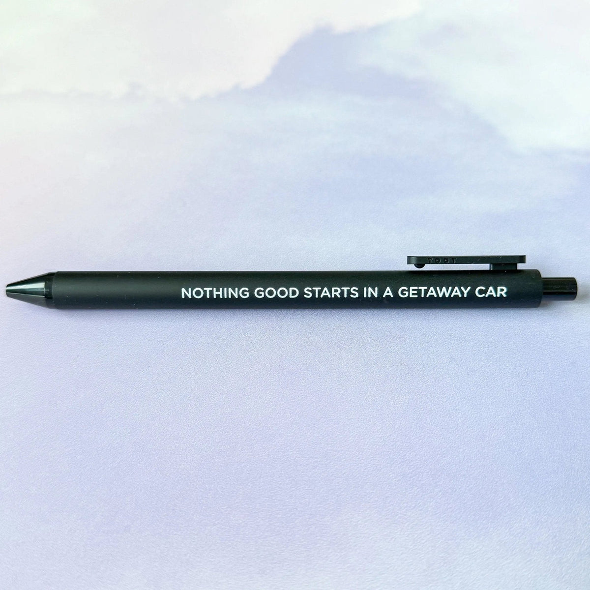 Getaway Car jotter gel pen flat lay — black barrel reputation era desk pen by indie artist MangoIllustrated