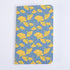 A pocket notebook with a blue background featuring a yellow floral pattern of gingko leaves.