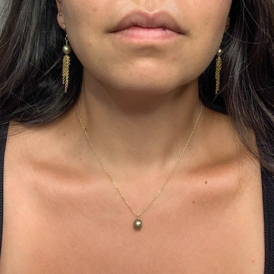 image of single pearl on gold chain on model
