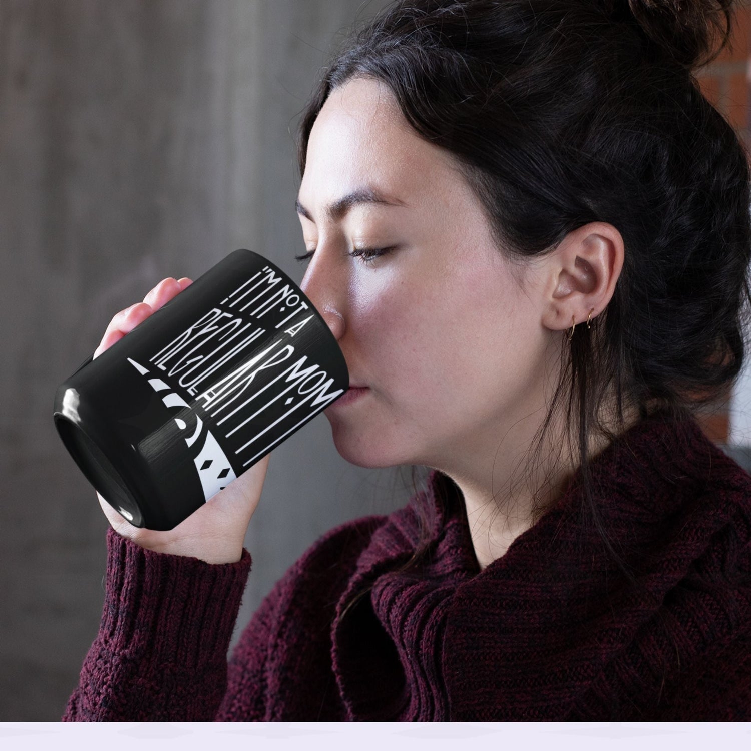 Woman with dark hair drinking from black goth mom mug showing I&