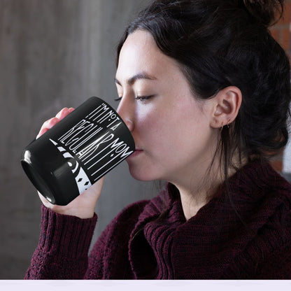 Woman with dark hair drinking from black goth mom mug showing I&