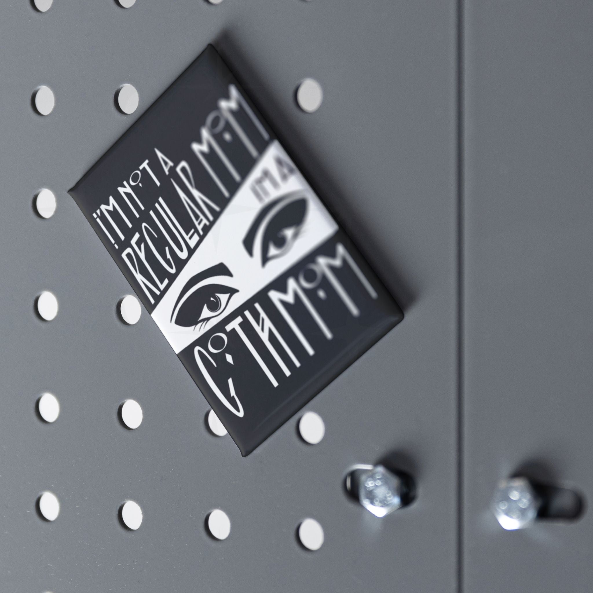 Goth mom fridge magnet displayed at an angle on a grey pegboard surface with chrome hardware visible
