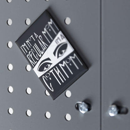 Goth mom fridge magnet displayed at an angle on a grey pegboard surface with chrome hardware visible