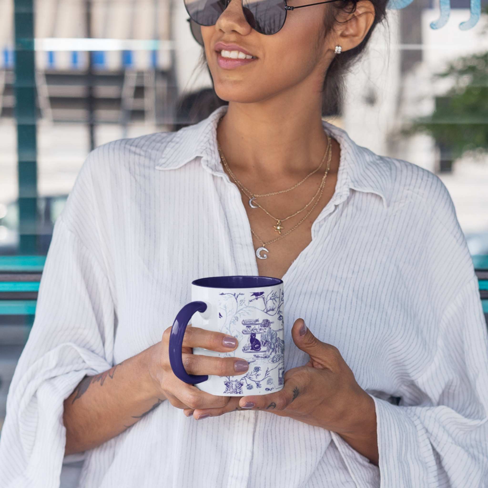 Woman holding a blue and white gothic toile zombie pattern mug with navy handle outdoors