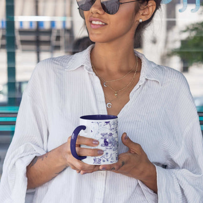 Woman holding a blue and white gothic toile zombie pattern mug with navy handle outdoors