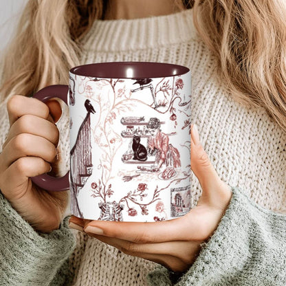 Person holding an oxblood red Victorian zombie toile mug with a maroon interior
