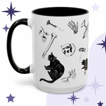 Black and white gothic pattern mug with scattered skulls, bones, black cats, and a raven in a ditsy layout