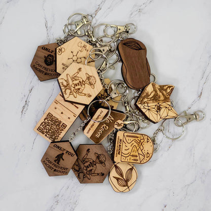 The caffeine molecule wooden keychain shown with the wider PRWMade wooden keychain collection in maple and walnut, for scale and wood comparison