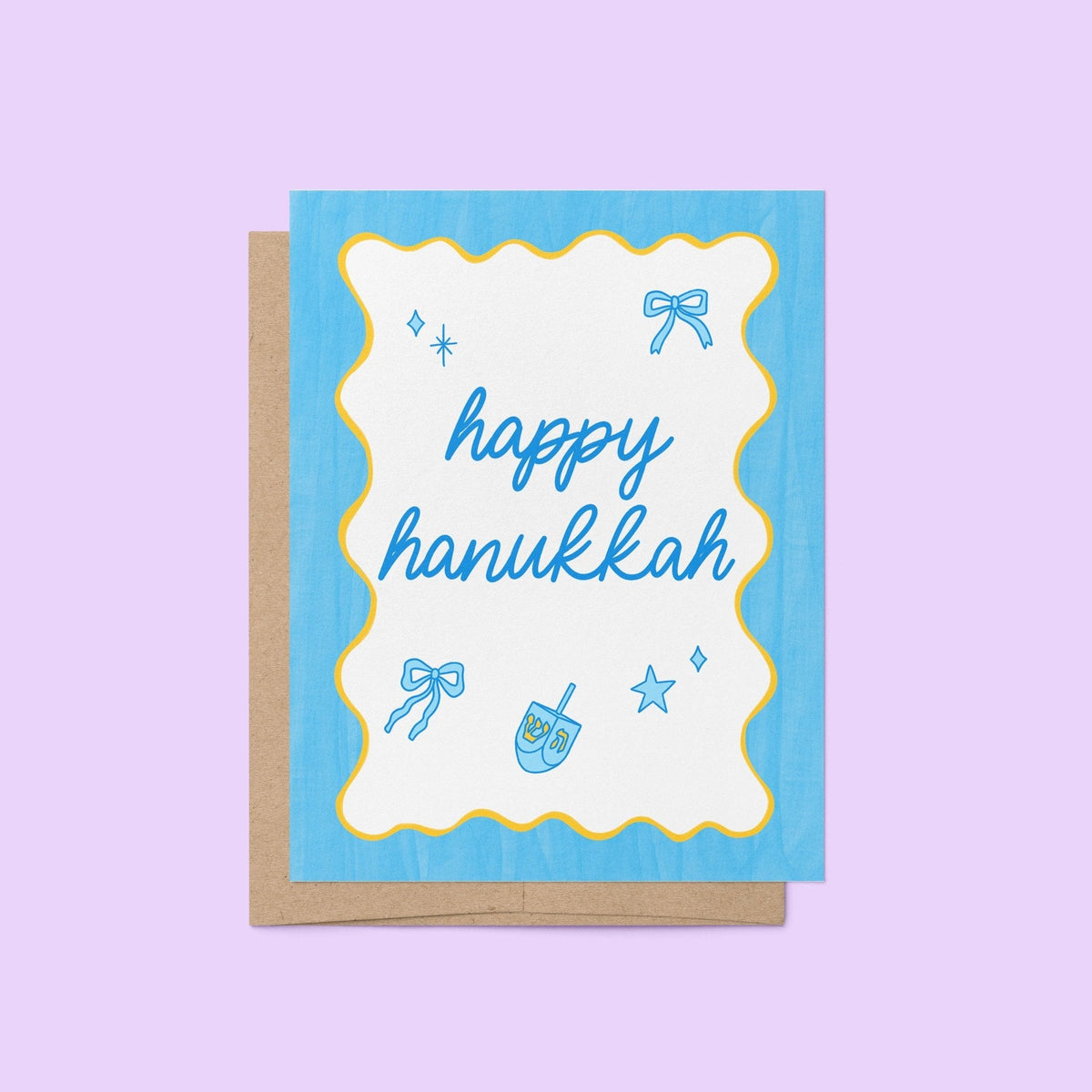 Happy Hanukkah Greeting Card flat lay — modern blue and white Festival of Lights card styled on a desk by indie artist MangoIllustrated