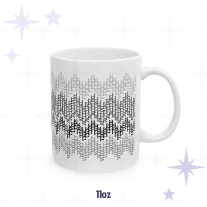 White ceramic 11oz coffee mug with monochrome gray fair isle zigzag pattern hiding the repeating phrase what the actual fuck in cross-stitch typography

