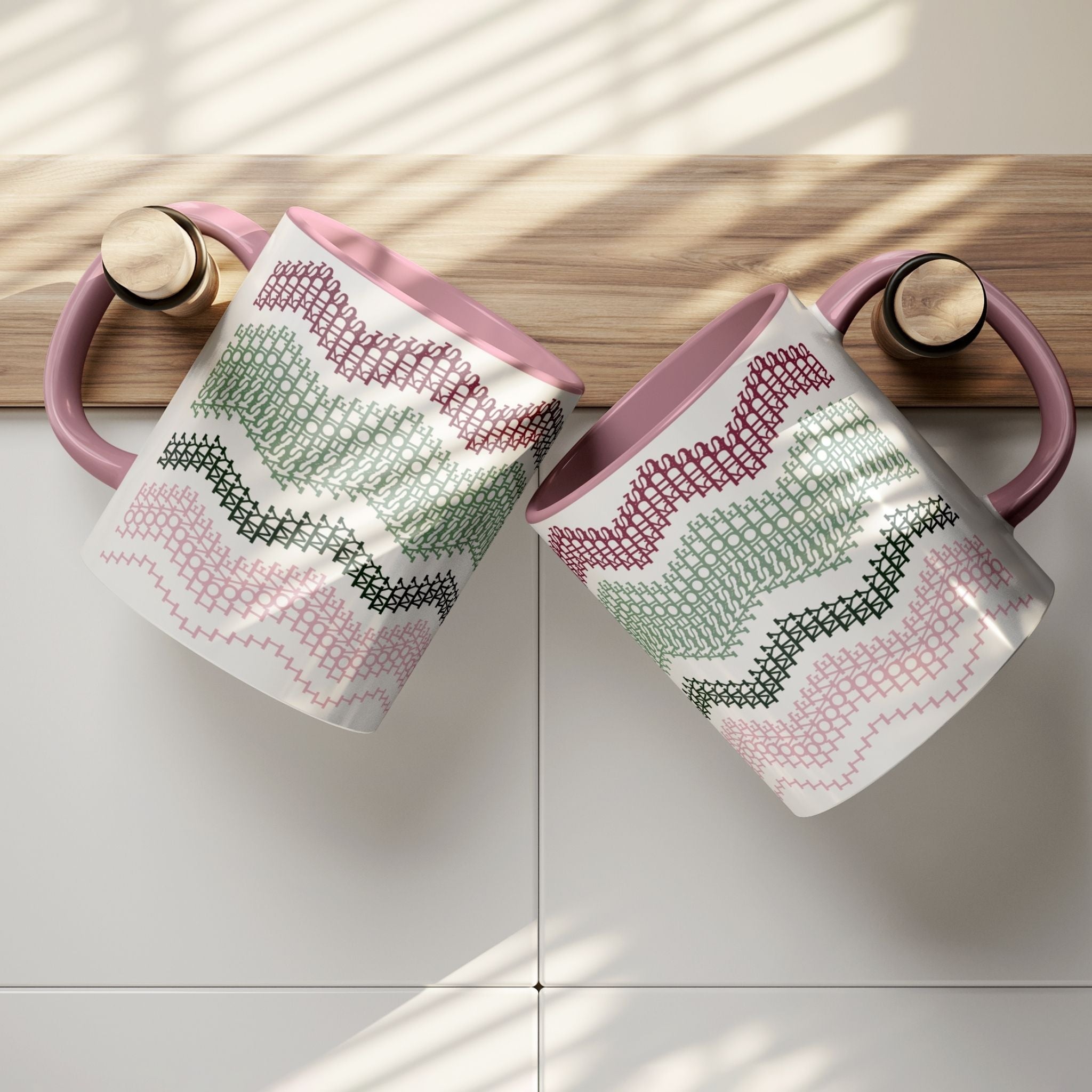 Two Preppy &amp; Pink hidden message mugs resting on a wooden kitchen shelf ledge against white tile — overhead lifestyle shot showing both sides of the typographic pattern