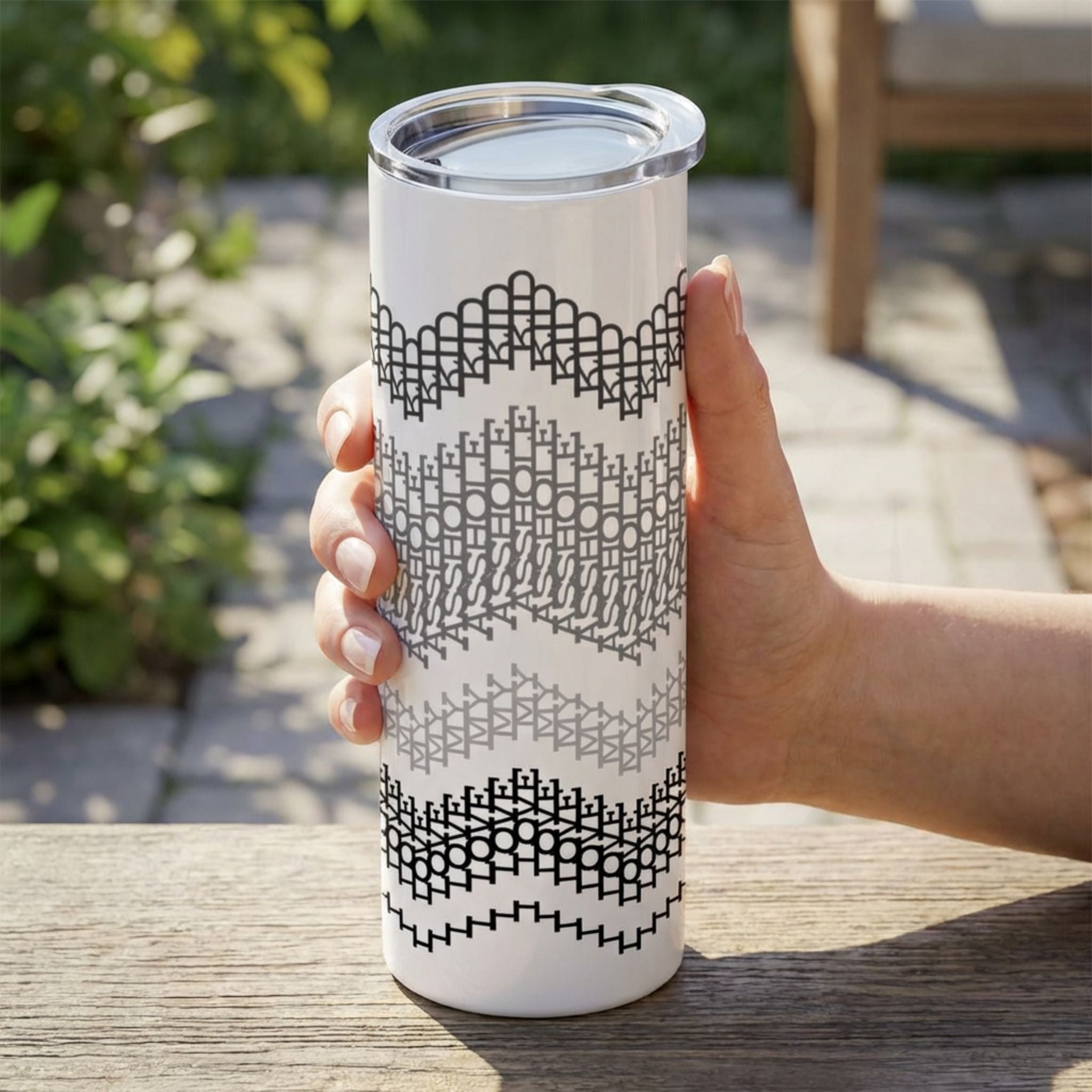 Gray Stripes I Love My Asshole Kid fair isle tumbler held outdoors on a patio — four tonal bands in black, charcoal, medium gray, and light gray on white stainless steel