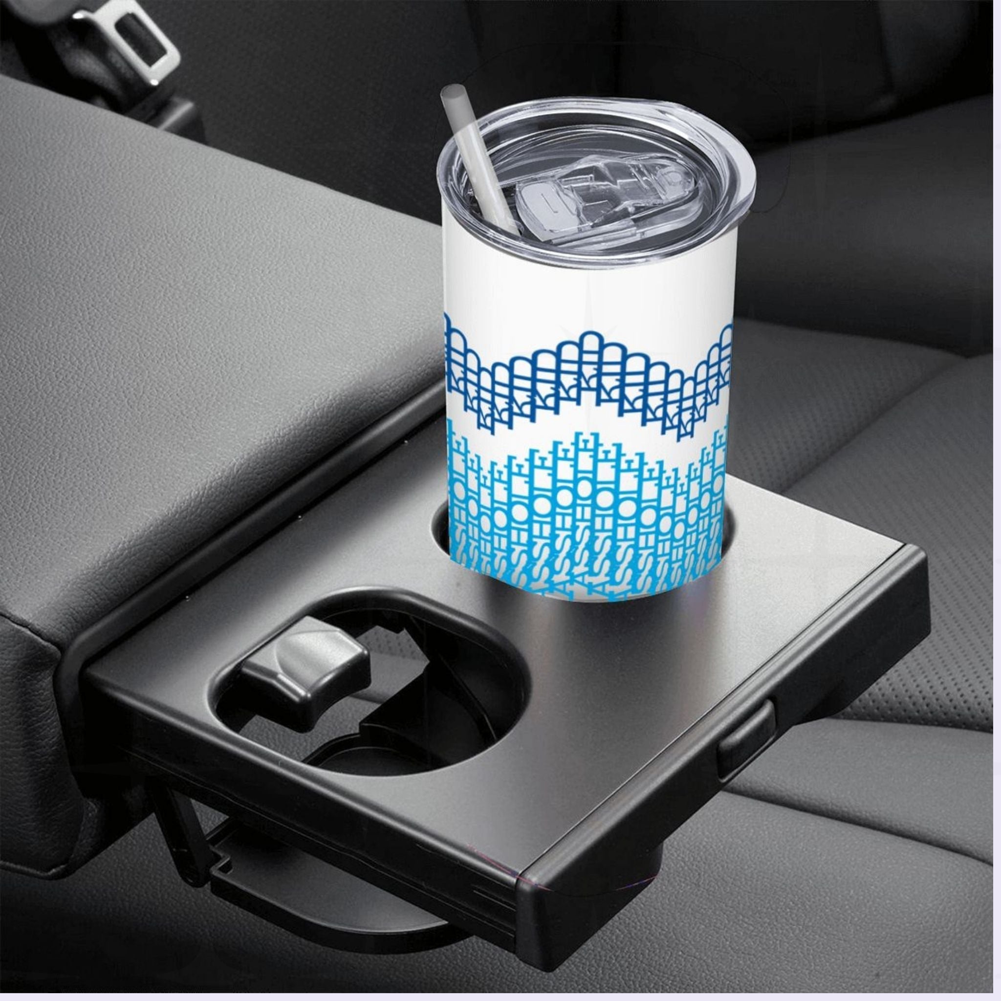 Ocean Stripes hidden profanity tumbler in a car cup holder with straw in lid — navy, sky blue, teal, and forest green typographic cross-stitch pattern bands on white 20oz tumbler