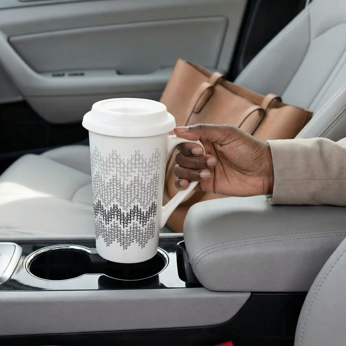 Gray stripes hidden profanity latte mug in car cup holder, commuter lifestyle photo showing geometric swear word pattern on 16oz ceramic travel mug