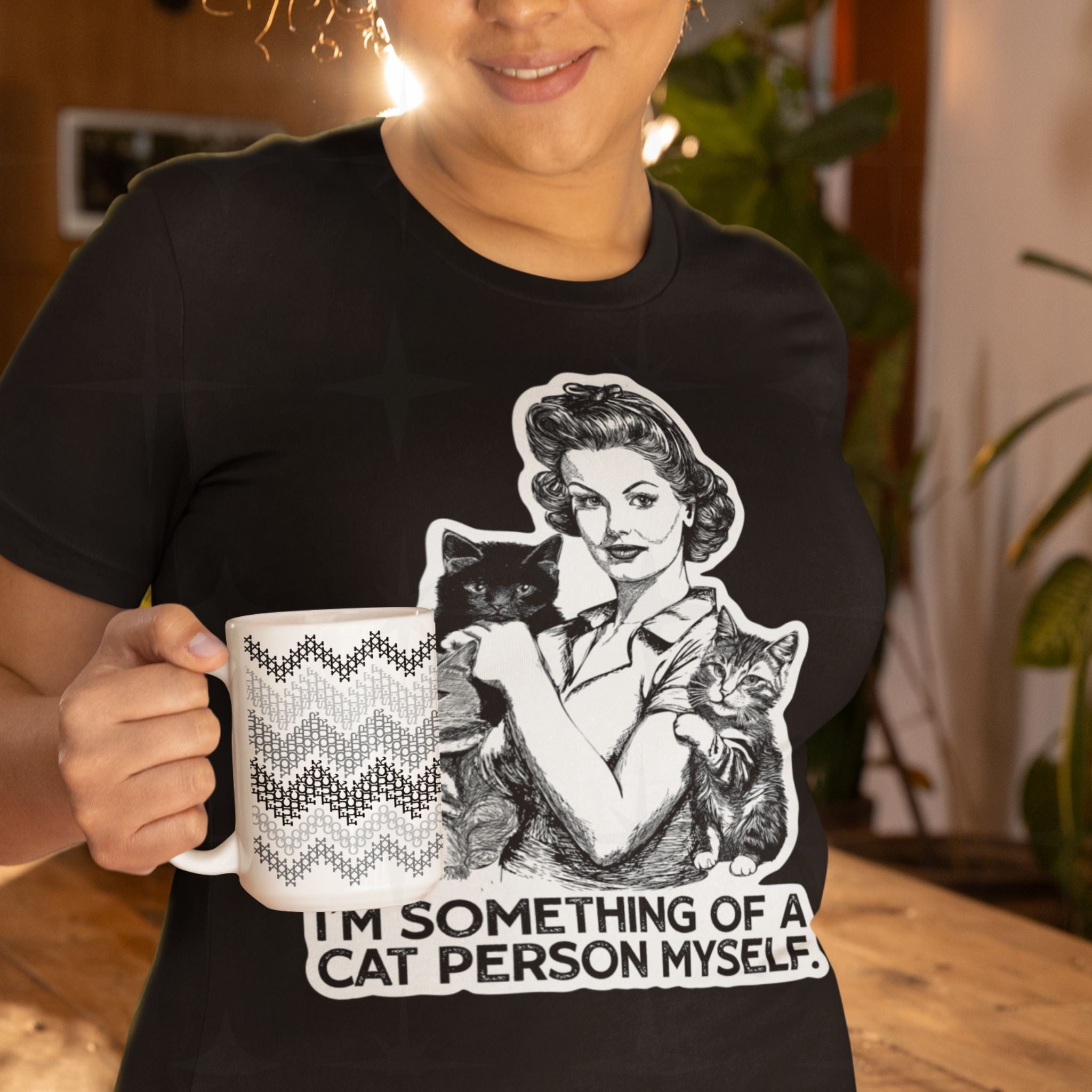 Woman wearing retro cat lady graphic tee holding hidden profanity ceramic mug in gray cross stitch chevron pattern