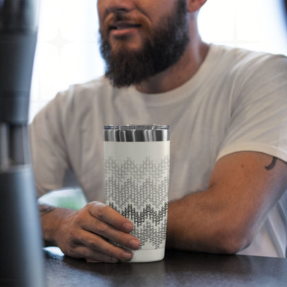 Man at kitchen counter holding gray stripes hidden message tumbler, cross-stitch swear word pattern visible on stainless steel cup