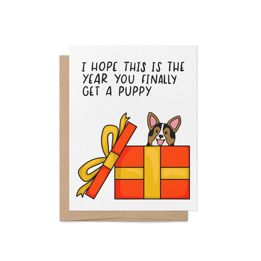 Hope This Is the Year You Finally Get a Puppy holiday card — hand lettered card with a puppy popping out of a red and yellow gift box, 4.25 x 5.5 inch folded card, by MangoIllustrated