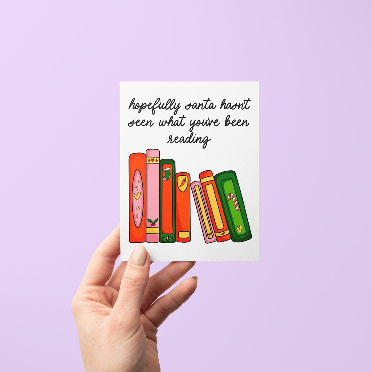 Hopefully Santa Hasn’t Seen What You’ve Been Reading Christmas card flat lay — funny holiday card for book lovers and romance readers by indie artist MangoIllustrated
