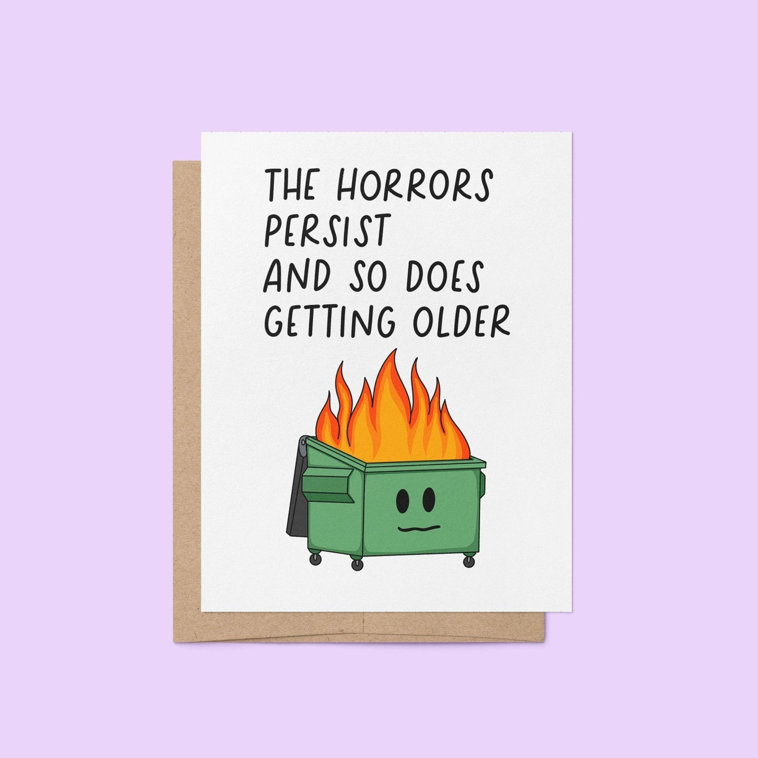 Funny birthday card with illustration of a flaming dumpster and the words “The horrors persist and so does getting older” in bold text, blank inside with kraft envelope.